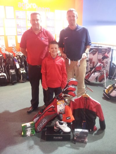 Adam and his Dad Colin (blue shirt) are pictured with their prize at the american golf store in Belfast