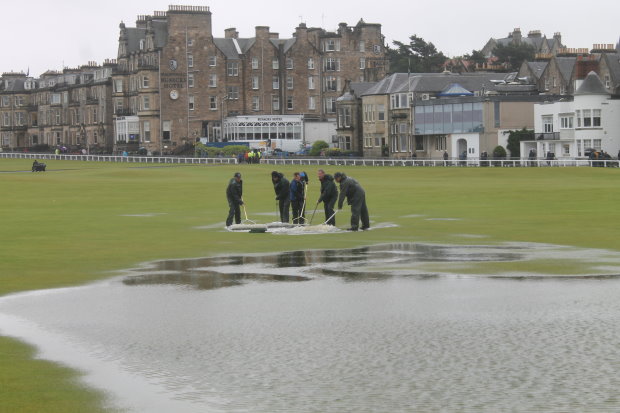 The home greenkeeping team clearing water from the 18th on Friday morning